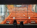 Female feet wearing black shoes and tights stands on a glass floor inside the Tokyo Tower in Japan. View of observatory below. Royalty Free Stock Photo