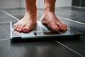 Female feet with weight scale in the bathroom