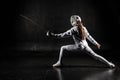 Female fencer on black background