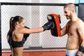 Female fighter trains in a fighting cage