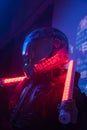 Woman in Futuristic Tactical Black Suit and Motorcycle Helmet with Neon Lamps