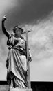 Female figure holding the long cross