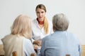 Female financial advisor talking consulting senior aged couple a Royalty Free Stock Photo