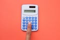 Female Finger press button Modern blue digital calculator is on a orange background. Royalty Free Stock Photo