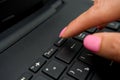 Female finger presses delete button on black laptop Royalty Free Stock Photo