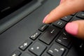 Female finger presses delete button on black laptop Royalty Free Stock Photo