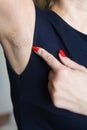 Female finger shows unshaven armpit. Royalty Free Stock Photo