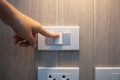 Female finger is turn on or off on light switch on white wall at home. Energy Saving, power, electrical and lifestyle concepts