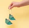 Female hand holding newborn baby shoes with laces Royalty Free Stock Photo