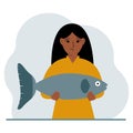 A female fisherman holds a large fish, proud of good fishing or hunting. Hobby, fishing concept. Royalty Free Stock Photo