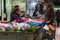 female fishmonger talking to customer in the old indoor Alicante market hall Royalty Free Stock Photo