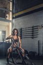 Female fitness model exercising with battle rope. Royalty Free Stock Photo