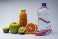 Female fitness still life. Healthy food, fruit, juice and water on grey background Royalty Free Stock Photo