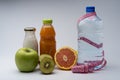 Female fitness still life. Healthy food, fruit, juice and water on grey background Royalty Free Stock Photo