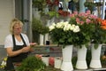 Female florist arranges flowers on the market in P