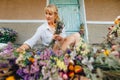 Female florist creates beautiful bouquets of dried flowers grown in the country. The decorator sits in dried flowers on the street