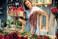 Florist decorates flower bouquet in shop closeup