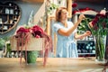 Female florist decorates flowers in shop