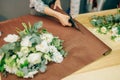 Female florist hands cuts decoration with scissors