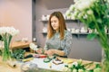 Female florist prepares flower composition