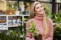 female florist smiling and holding plant in her hands