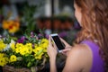 Female florist taking photogrpah of flower basket Royalty Free Stock Photo