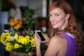 Female florist taking photogrpah of flower basket Royalty Free Stock Photo