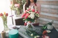 Female florist at work: pretty young dark-haired woman making fashion modern bouquet of different flowers. Women working Royalty Free Stock Photo