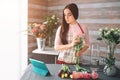 Female florist at work: pretty young dark-haired woman making fashion modern bouquet of different flowers. Women working Royalty Free Stock Photo