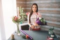 Female florist at work: pretty young dark-haired woman making fashion modern bouquet of different flowers. Women working Royalty Free Stock Photo