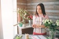 Female florist at work: pretty young dark-haired woman making fashion modern bouquet of different flowers. Women working Royalty Free Stock Photo