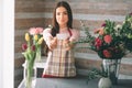 Female florist at work: pretty young dark-haired woman making fashion modern bouquet of different flowers. Women working Royalty Free Stock Photo