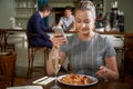 Female Food Blogger Posting Online Review Of Restaurant Meal Using Mobile Phone