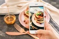 Female food photographer with mobile phone taking picture of pancakes Royalty Free Stock Photo