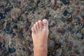 Female foot on a background of sea water.