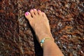 Female foot on the beach stone Royalty Free Stock Photo