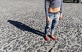 Female foot in torn jeans and red loafers