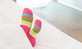 Female foot in warm stripe wool sock ,Woman sleeping and relaxing in bed concept. Warm and cozy white socks in the bed