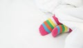 Female foot in warm stripe wool sock ,Woman sleeping and relaxing in bed concept. Warm and cozy white socks in the bed