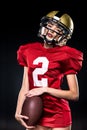 Beautiful female american football player in sportswear and helmet posing