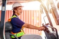 Female forklift operator working in a warehouse. Portrait of young Indian woman driver sitting in forklift and smiling working in Royalty Free Stock Photo