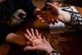 FEmale fortuneteller with a cat holds male palms.