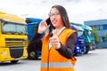 Female forwarder in front of trucks on a depot Royalty Free Stock Photo