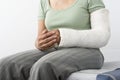 Female With Fractured Hand Sitting On Bed