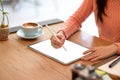 Female freelance graphic designer sketching her graphic digital photo art on modern tablet