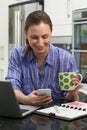 Female Freelance Worker Sending Text Message On Mobile Phone In