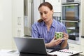 Female Freelance Worker Using Laptop And Drinking Coffee In Kitchen At Home