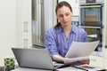 Female Freelance Worker Using Laptop In Kitchen At Home