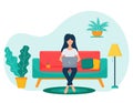 A female freelancer with dark hair sits cross-legged on the sofa and works with a laptop. The concept of remote work, study at