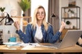 Female freelancer in eyeglasses meditating at table, feeling relaxed Royalty Free Stock Photo